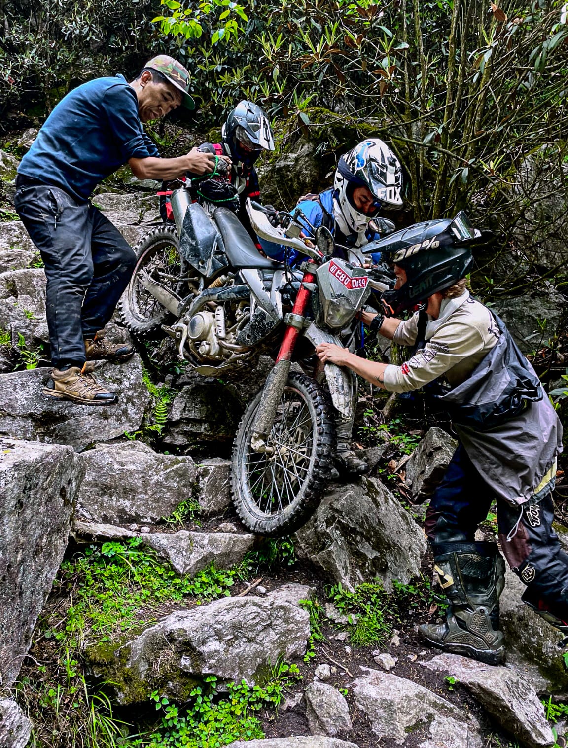 Rider crossing a long suspension bridge over a river valley